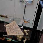 Dans la vitre « Musée des épaves » : plusieurs supports naturels inhabituels, ayant provoqué l’impulsion de l’écriture, en l’occurrence, un cerf-volant de papier et sa ribambelle de nœuds papillons