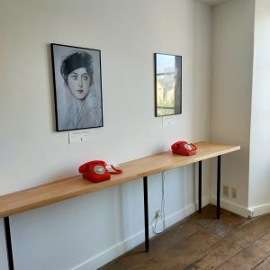 La salle des téléphones rouges qui permettent d’accéder à des enregistrements audio de correspondances personnelles et cartel de présentation du dispositif sur Suzanne Giraudoux.