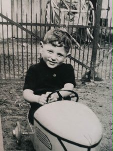 Photographie de Georges Perec enfant dans une voiture à pédales, exposée aux Archives de Paris à l’occasion de Georges Perec, archives d’une enfance.